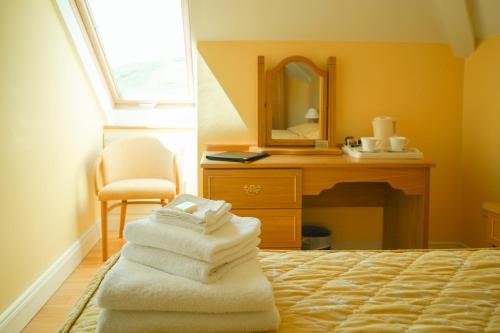a bedroom with a bed and a mirror and towels at Inch Beach House B&B in Inch
