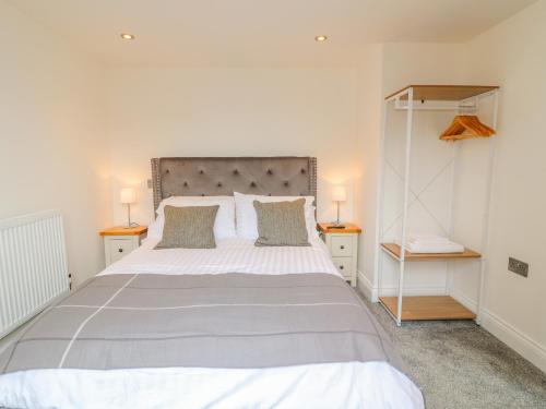 ein Schlafzimmer mit einem großen Bett mit zwei Nachttischen in der Unterkunft Lifford Coach House in Sutton upon Trent
