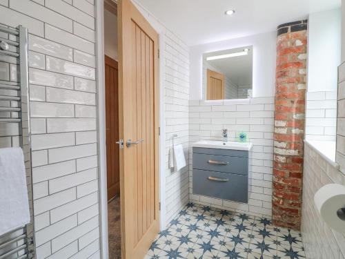 ein Badezimmer mit einem blauen Waschbecken und einem Spiegel in der Unterkunft Lifford Coach House in Sutton upon Trent