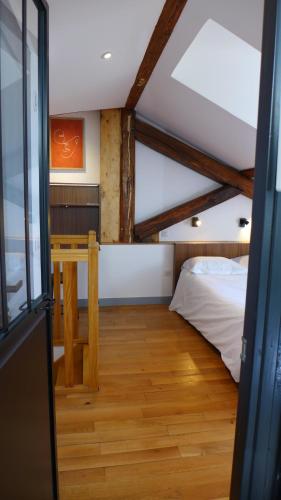 a attic room with a bed and a table at Les Versaillaises in Versailles