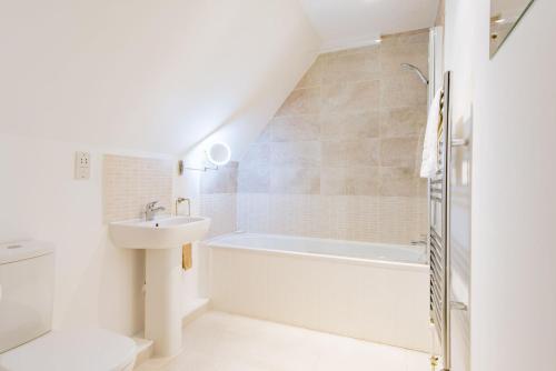 a bathroom with a sink and a bath tub at The Loft at Emperor Court by Bloom Stays in Canterbury