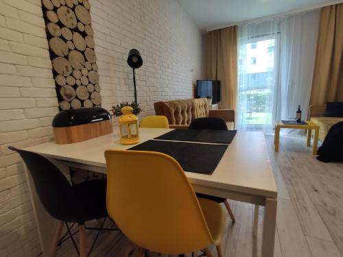 a living room with a dining room table with yellow chairs at Black House in Jelitkowo