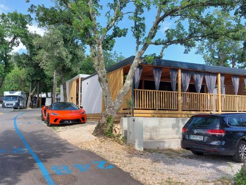 una casa con dos coches estacionados frente a ella en MOBIL HOME SELCE en Selce