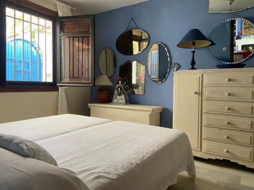 a bedroom with a bed and a dresser and mirrors at Villa Playa Mojacar in Mojácar