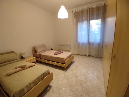 mały pokój z 2 łóżkami i oknem w obiekcie Casa al mare w Lido di Venezia