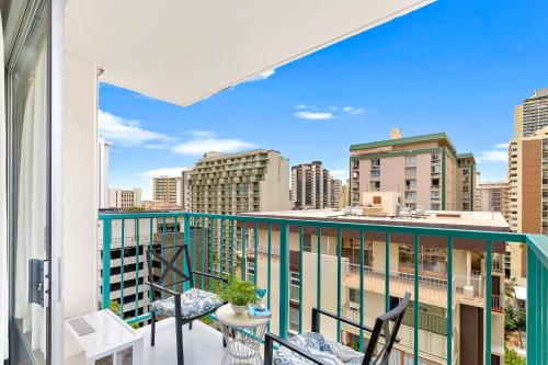 a balcony with chairs and a view of the city at Beautiful Studio in the Heart of Vibrant Waikiki in Honolulu
