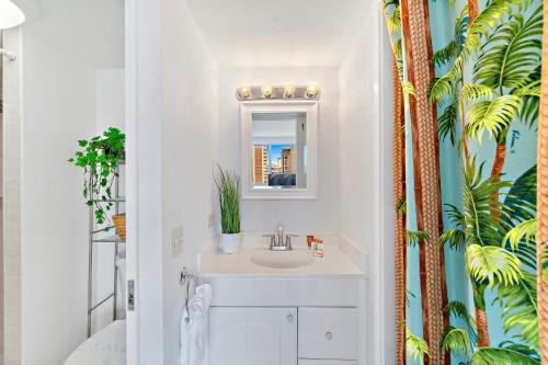 La salle de bains est pourvue d'un lavabo et d'un miroir. dans l'établissement Beautiful Studio in the Heart of Vibrant Waikiki, à Honolulu
