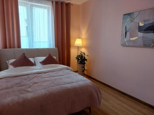 una camera con un grande letto e una finestra di Apartament Rodzinny a Mrągowo