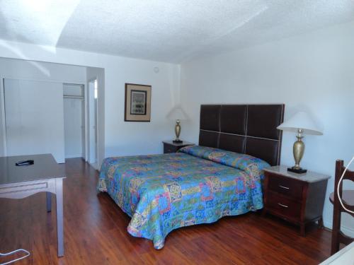 a bedroom with a bed and a wooden floor at Travel Inn in North Hills