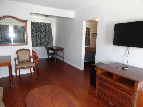 a living room with a flat screen tv and a table at Travel Inn in North Hills