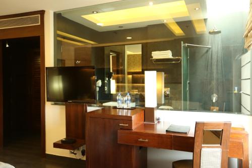 een badkamer met een bureau en een glazen douche bij Hotel Icon in Chandīgarh