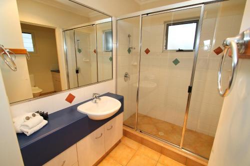 a bathroom with a shower, sink, and toilet at Edge on Beaches in Agnes Water
