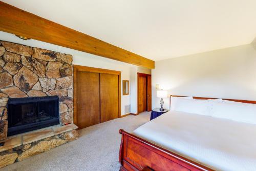 a bedroom with a bed and a stone fireplace at Tahoe Enchantment in Zephyr Cove