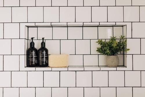 a shelf with two bottles of wine and a plant at Spotless Modern Home Close to LAX & Sofi Stadium in Inglewood