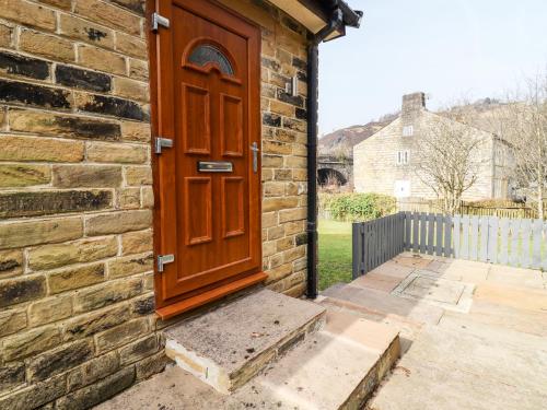 a wooden door on the side of a brick building at Canal View in Todmorden
