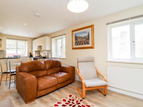 a living room with a leather couch and a chair at Canal View in Todmorden