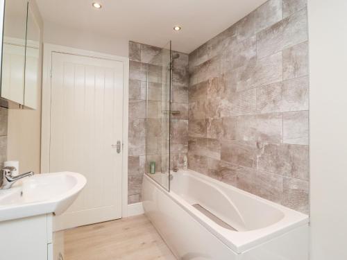 a bathroom with a bath tub and a sink at Canal View in Todmorden