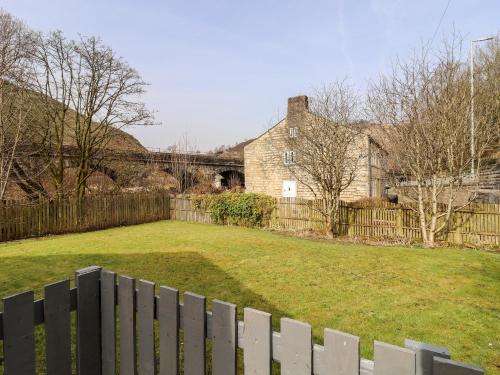 a fence in front of a yard with a house at Canal View in Todmorden