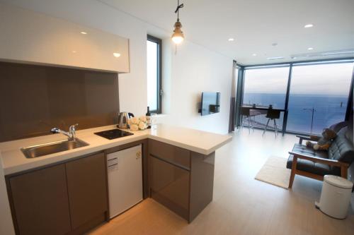 a kitchen with a sink and a living room at Vista Resort Jeju in Jeju