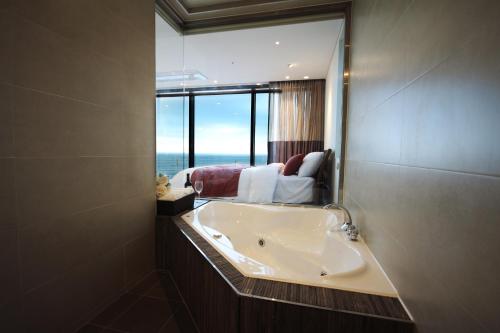a bathroom with a sink and a large mirror at Vista Resort Jeju in Jeju