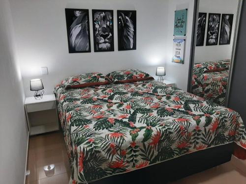 a bedroom with a bed with a colorful comforter at Ribeirania-Zeus 67-Garagem-WIFI-Pet Friendly in Ribeirão Preto