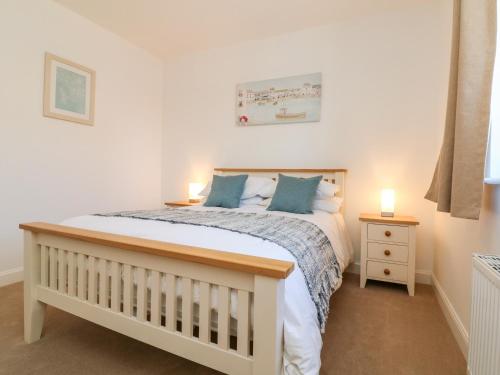 a bedroom with a bed and two lamps on a night stand at 1 Marsh Gardens in Dunster