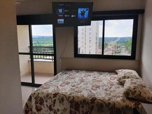 1 dormitorio con 1 cama, TV y ventanas en Nova Aliança 66-wifi-estacionamento-pet friendly, en Ribeirão Preto