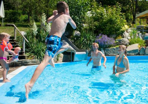 a group of people playing in a swimming pool at Familienhotel Post in Millstatt