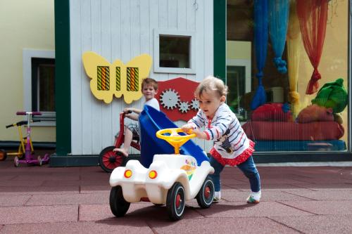 two little girls playing with a toy car at Familienhotel Post in Millstatt