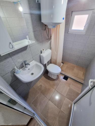 a bathroom with a white toilet and a sink at Adventure Tara in Foča