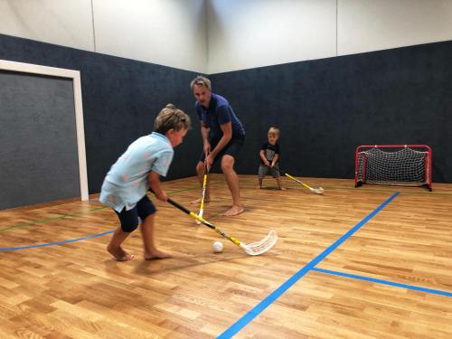 a man and two children playing a game of squash at Familienhotel Post in Millstatt