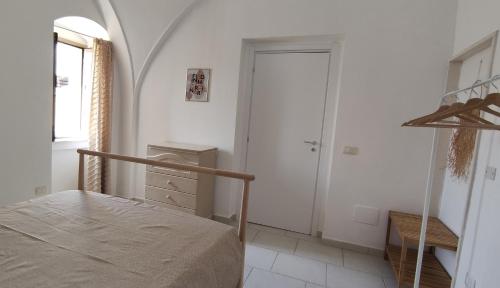 a bedroom with a bed and a window and a door at Appartamenti Boho Chic in Sannicandro di Bari