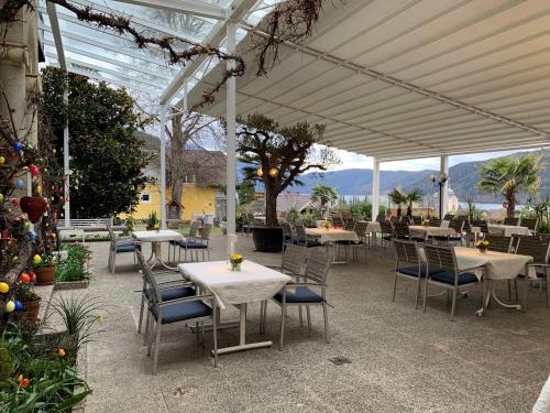 a patio with tables and chairs under a white canopy at Familienhotel Post in Millstatt