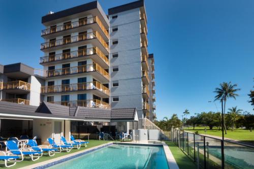 un hotel con piscina al lado de un edificio en Coral Towers Holiday Suites en Cairns