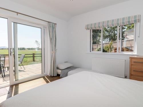 a bedroom with two beds and a large window at Robins Corner in Weston-super-Mare