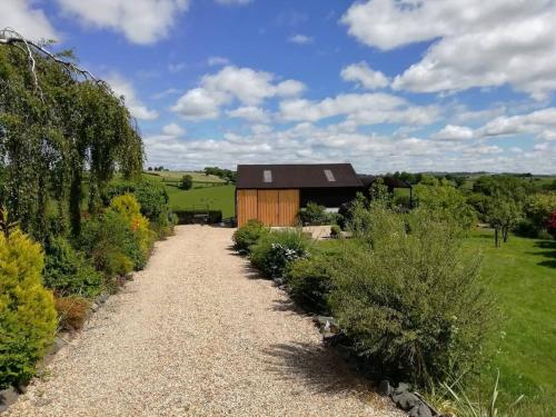 a gravel path leading to a garden with a wooden building at Country Home with Gardens in Newtown