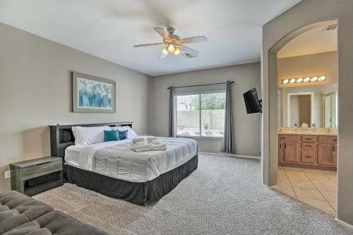 a bedroom with a bed with a ceiling fan at Goodyear Desert Oasis with Patio and Game Room! in Goodyear