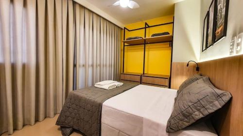 a bedroom with a bed and a yellow wall at Nova Aliança 103-wifi-estacionamento-3 hóspedes in Ribeirão Preto