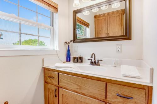 a bathroom with a sink and a mirror at River Rock Cottage in Fredericksburg