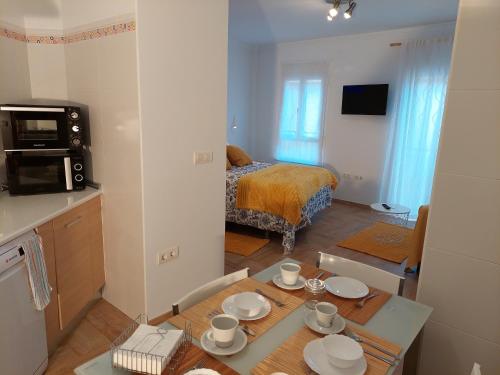 una camera con tavolo e una cucina con letto di Citrus Suite by Alhaurín Loft City Center ad Alhaurín de la Torre