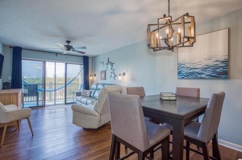 a dining room with a table and chairs and a couch at BEAUTIFUL BEACHFRONT-Oceanfront First Floor 2BR 2BA Condo in Cherry Grove, North Myrtle Beach! RENOVATED with a Fully Equipped Kitchen, 3 Separate Beds, Pool, Private Patio & Steps to the Sand! in Myrtle Beach