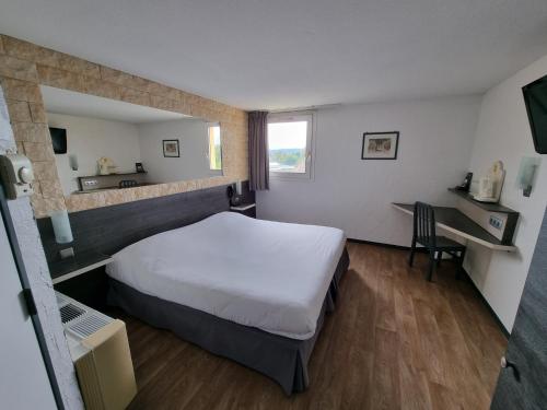 a hotel room with a bed and a desk at Hôtel Restaurant Le Relais - Pau Nord in Lons