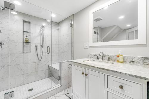 een witte badkamer met een douche en een wastafel bij The Studio in Seattle