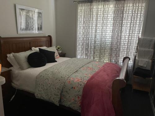 a bedroom with a bed and a window with curtains at Gibbagunyah Manor Workers Accommodation Only in Muswellbrook