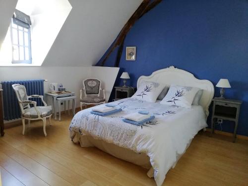 1 dormitorio con 1 cama blanca grande y paredes azules en Clos de la ruche, en Cour-sur-Loire