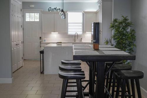 uma cozinha com um balcão e bancos numa cozinha em Modern Townhouse with Pool Close to Disney & Silver Spurs Arena em Kissimmee