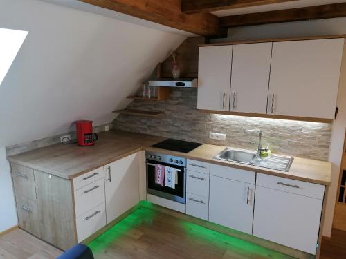 a small kitchen with white cabinets and a sink at Appartment Romy in Radstadt