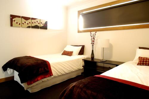 a hotel room with two beds and a window at Abode Bendigo Apartments in Bendigo