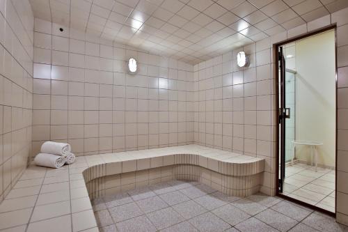 a tiled bathroom with a tub and a shower at Transamerica Executive Curitiba Batel in Curitiba