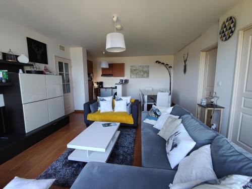 a living room with a couch and a table at Le Cosy Pyrénées pied de pistes Sérias in Germ